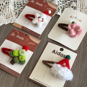 Detailed view of four wool felt Christmas hair clips including star and tree designs