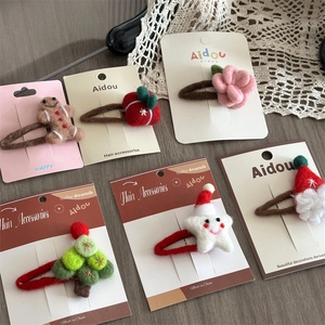 Detailed view of handmade wool felt Christmas hair clips set in diverse holiday shapes