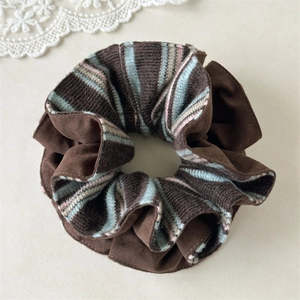 Détails de la texture en velours marron et du tissu à rayures colorées du chouchou