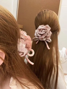 Détail du chouchou rose en velours avec rubans, vue de côté et de l'arrière du nœud