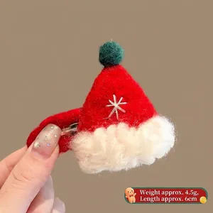 Detail of red wool felt Santa hat hair clip with white snowflake and green pompom