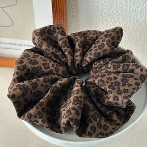 Detail of vintage double-layer leopard print velvet scrunchie in a white ceramic tray