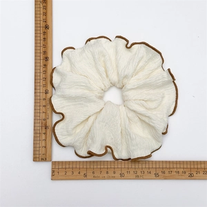 Chouchou géant crème avec bordure surjetée marron et texture gaufrée, largeur 12,5cm