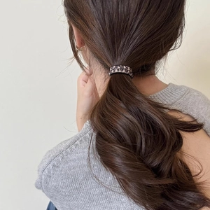Vista dettagliata dell'elastico per capelli leopardato marrone sulla coda della modella