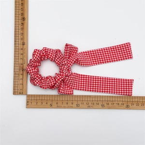 Red plaid checkered hair scrunchie with long ribbon streamers for ponytail styling