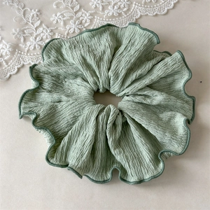 Gros plan du chouchou en seersucker vert clair avec couture de bordure vert foncé