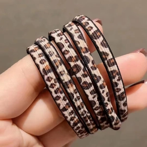 Primo piano di cinque elastici per capelli leopardati con texture ed alta elasticità