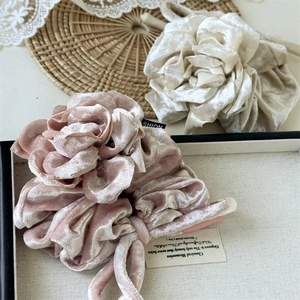 Détail de chouchous rose et beige en velours en forme de rose aux pétales superposés