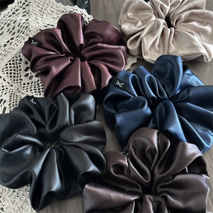 Premium thick satin and faux leather scrunchies in five colors with bow labels