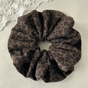 Close-up of a velvet leopard print scrunchie with soft texture and vintage aesthetic