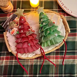 Dettaglio di cerchietti albero di Natale con stelle luminose e decorazioni festive