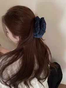 Detail der flauschigen Samttextur und der weichen Falten des übergroßen marineblauen Scrunchies