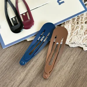Detail view of drop-shaped metal hair clips in black, burgundy, navy, and coffee colors