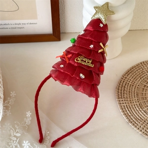 Dettaglio del cerchietto albero di Natale rosso con stella dorata e pompon colorati
