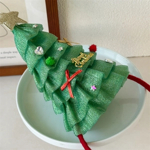 Vista dettagliata di un cerchietto con albero di Natale verde, stelle dorate e decorazioni