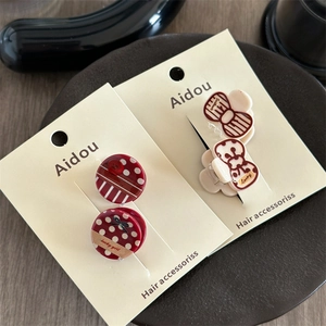Detail of red polka dot hair clips and white bear printed clips on display card