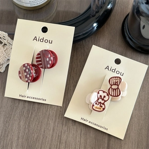 Chic red acrylic hair clips set with polka dot pattern on an elegant display card