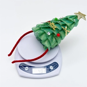 Cerchietto divertente ad albero di Natale con LED che pesa 40,1g su una bilancia