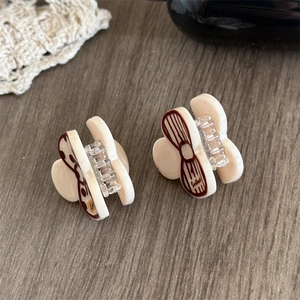 Detail of cream acetate hair clips with brown bows and Sweetheart lettering