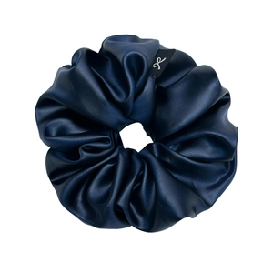 Navy blue satin silk scrunchie with large pleats and a minimalist logo tag