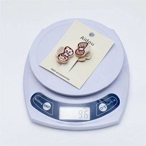 Detail showing a pair of cute Loopy character bow hair clips on a purple digital scale