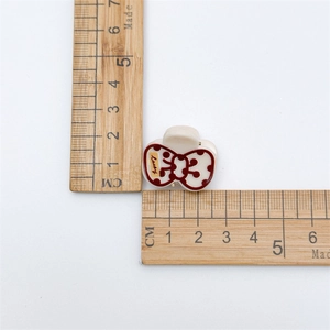 Mini acrylic hair clip in creamy white with red bow print and 2.5cm size scale