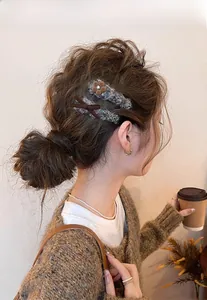 Dettaglio di fermagli per capelli con fiori e fiocchi di peluche e trama intrecciata