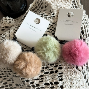 Primo piano di quattro elastici per capelli in peluche colorati in crema e rosa