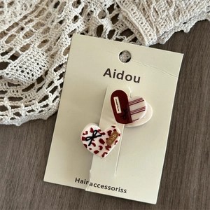 Detail of red heart-shaped acrylic hair clips with leopard and stripe patterns