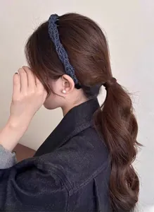 Vue détaillée de la pince à cheveux tressée bleu foncé avec fils argentés sur modèle