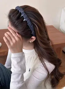 Détail de la pince à cheveux tissée bleu foncé avec chaîne en métal sur modèle