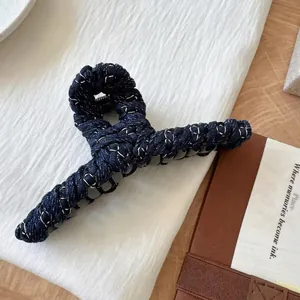 Pince à cheveux en denim bleu tissé avec fil argenté de style rétro sur tissu blanc