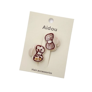 Set of two red acrylic hair clips with polka dots and stripes on a display card