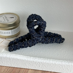 Détail de la pince à cheveux tissée bleu marine avec des fils métalliques dorés