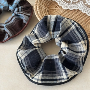 Close-up of plaid fabric scrunchies with neat stitching and elegant woven textures