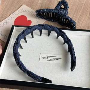 Vue détaillée de la texture tissée en denim bleu foncé sur la pince et le serre-tête