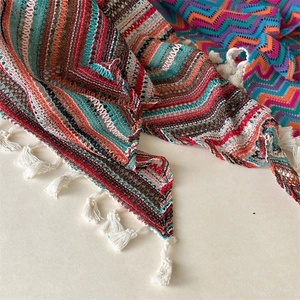 Detail van een bohemien gehaakte hoofddoek met golfpatronen en witte franje aan de rand