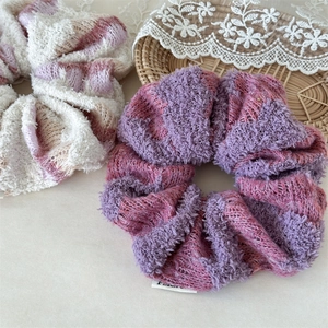 Detailed macro view of soft knit plush hair scrunchies in white and purple colors
