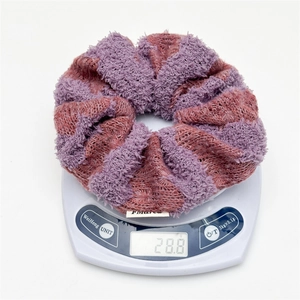 Detail shot showing the 28.8g weight of a striped purple knit scrunchie on a digital scale