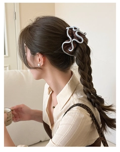 Detail view of coffee brown scrunchie with light blue wavy edges on braided hair