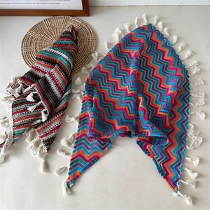 Macro-opname van kleurrijke gehaakte hoofddoek met bloemmotieven en katoenen kwastjes