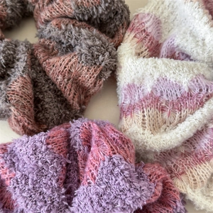 Three plush knitted scrunchies in mixed colors with soft mohair texture for hair styling