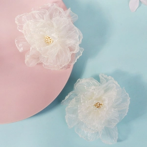 Barrettes à fleurs en maille blanche avec perles sur fond bleu pastel et rose poudré