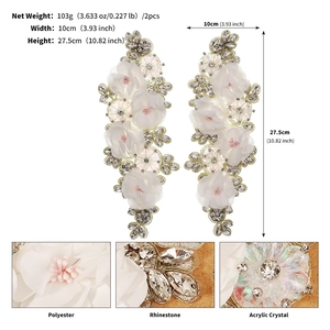 Macro detail of white fabric flowers with rhinestones and crystals for bridal gown