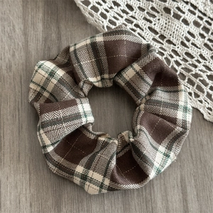 Close-up of vintage brown plaid scrunchie with thick woven texture and subtle sparkle