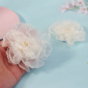 Gros plan détaillé des pinces à cheveux en forme de fleurs en résille blanche faites main