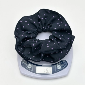 Detail showing high-quality black satin hair scrunchie with purple polka dots weighing 15.1g