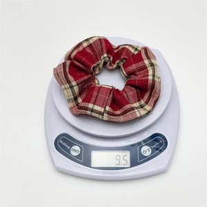 Detail showing red plaid scrunchie weight of 9.5g on a white electronic scale