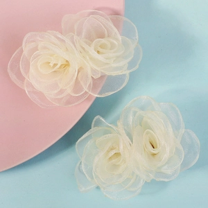 Vue détaillée des barrettes à fleurs en organza blanc avec des textures de pétales délicates
