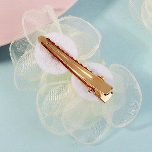 Détail de l'arrière d'une pince à cheveux fleur en organza avec pinces crocodiles et coussinets